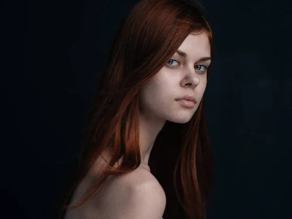 Portrait of a woman with red hair on a black background naked shoulders model — Stock Photo, Image