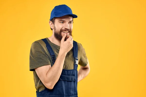 Hombre trabajador en uniforme servicio de entrega profesional fondo amarillo — Foto de Stock