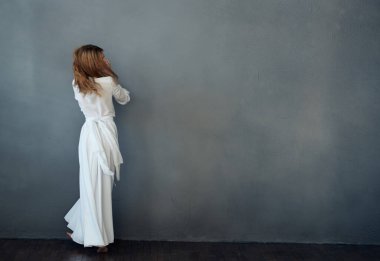 Beyaz elbiseli kadın göz kamaştırıcı dans ediyor