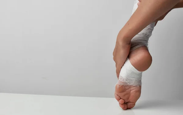 Obvázané nohy zranění medicína šedé pozadí problémy — Stock fotografie
