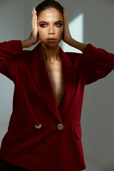 Bonito mulher segurando rosto cosméticos vermelho casaco modelo — Fotografia de Stock