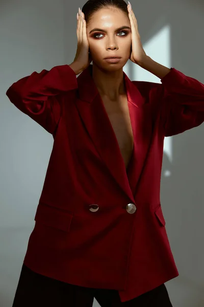 Привлекательная женщина в красной куртке с ярким макияжем лица — стоковое фото