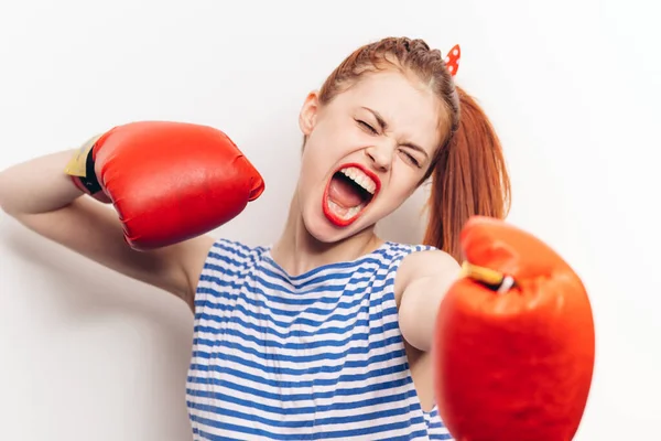 Mujer en guantes de boxeo y en una camiseta a rayas gritando estrés agresión — Foto de Stock