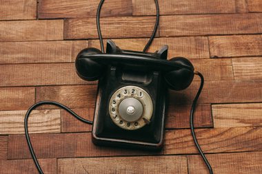 Teknolojinin klasik ahşap zemininde siyah retro telefon.
