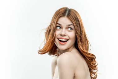 Omuzları çıplak, neşeli, güzel bir kadın. Arka plandaki gülümseme stüdyosu.