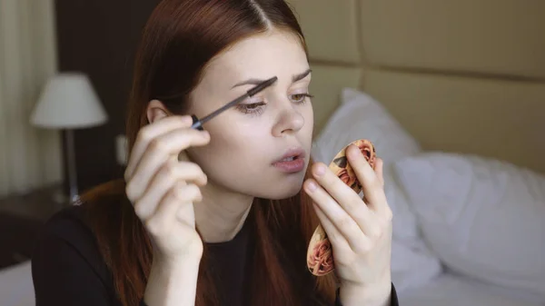 Vrouw in de slaapkamer van toepassing make-up op gezicht wimpers persoonlijke verzorging — Stockfoto