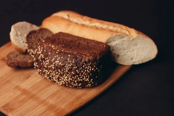 Un ürünleri somun ekmek baget ve ahşap tahta üzerinde hamur işleri — Stok fotoğraf