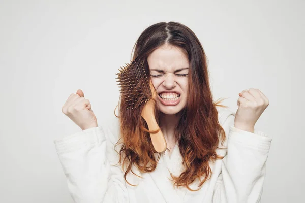 Pente preso no cabelo de uma mulher emocional em um fundo leve — Fotografia de Stock