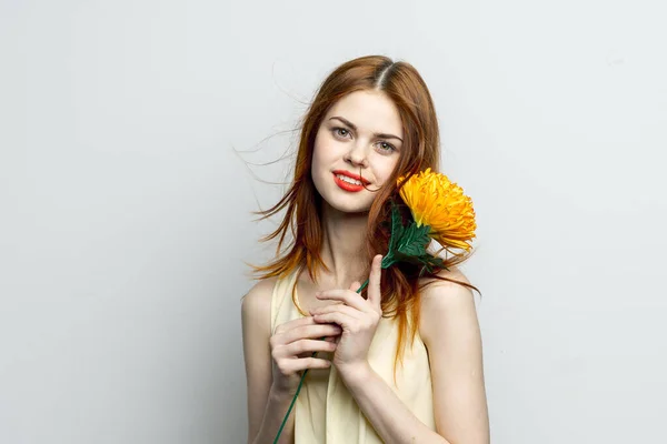 Vonzó vörös hajú nő sárga virággal a kezében mosoly elbűvölő érzelmek — Stock Fotó