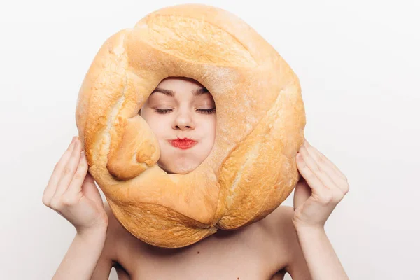 Mulher enérgica carece e segura um pão redondo na frente de seu rosto — Fotografia de Stock