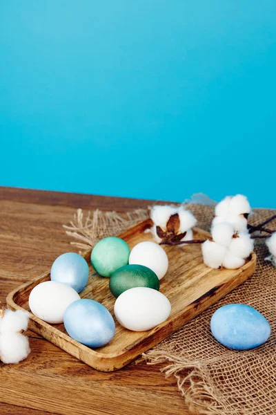 Huevos de Pascua decoración vacaciones tablero de madera fondo azul —  Fotos de Stock