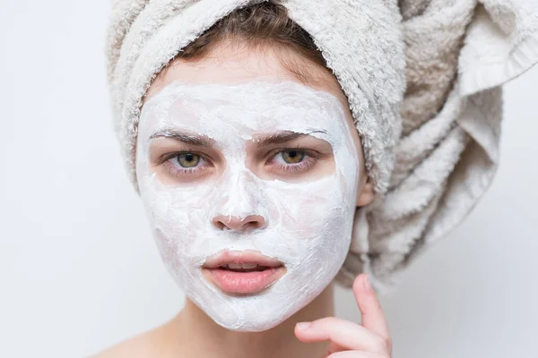 Jolie femme avec serviette sur la tête masque crème sur le visage gros plan — Photo