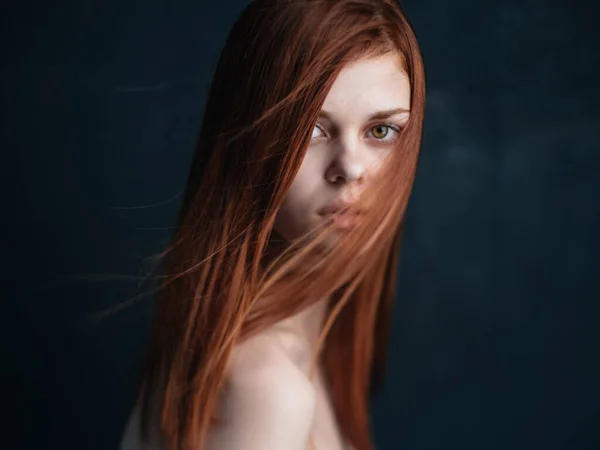 Närbild beskärd bild av en kvinna med rött hår ser fram emot på en svart bakgrund — Stockfoto