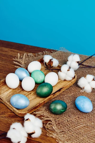 Huevos de Pascua pintados sobre tabla de madera verbena flores vacaciones fondo azul —  Fotos de Stock