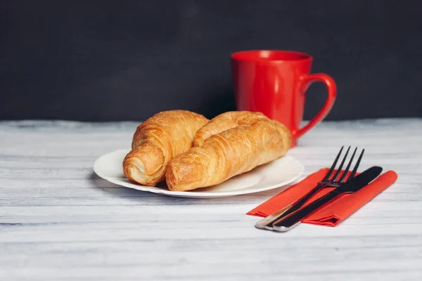 Croissants em uma chapa uma xícara de café sobremesa de mesa de madeira — Fotografia de Stock