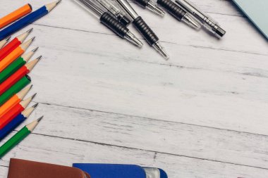 Ahşap bir masada çok renkli kartvizit tutucular ve kalemler kırtasiye kalemleri.