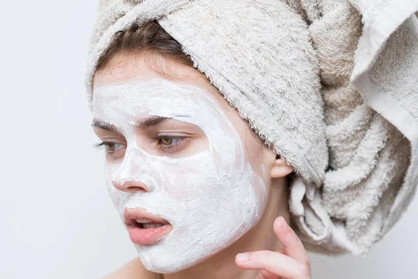 Bonita mujer con toalla en la cabeza máscara de crema en la cara de cerca —  Fotos de Stock