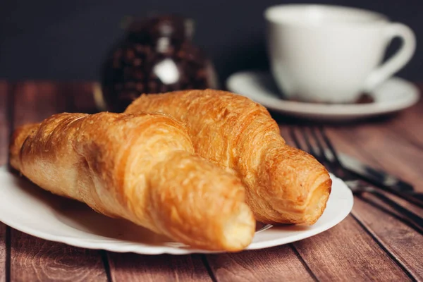 Fresh croissants on a saucer table setting breakfast — Stock Photo, Image