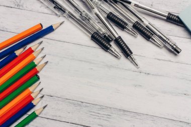 Kırtasiye kartı sahipleri tahta masa ofis malzemelerinin üzerine renkli kalemler.