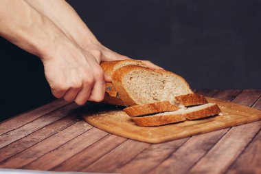 Tahta kesme tahtasında taze ekmek dilimliyorum.