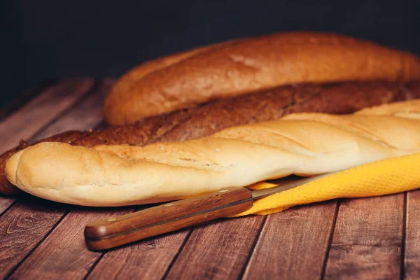 Szeletelni egy kenyeret a vágódeszkán konyha eszik reggeli friss illata — Stock Fotó