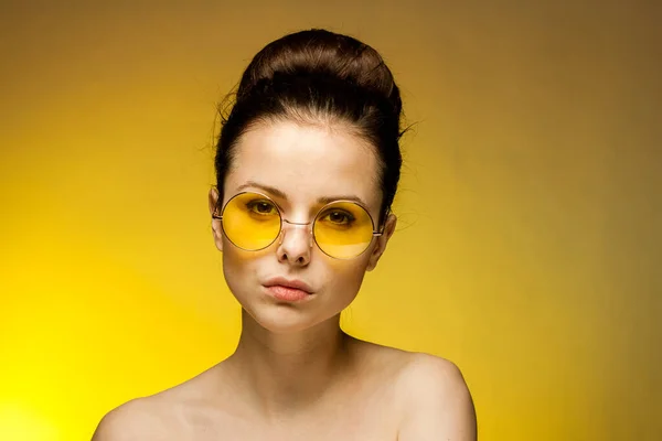 Esmer, çıplak omuzlu, sarı gözlükleri olan çekici bir kadın. — Stok fotoğraf