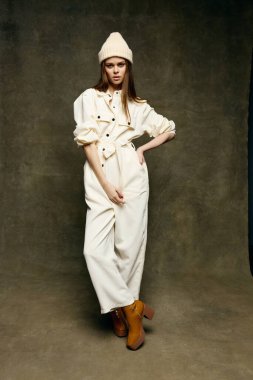 Takım elbiseli çekici bir esmer ve kahverengi arka planda tam gelişim gösteren çizmeleri var.