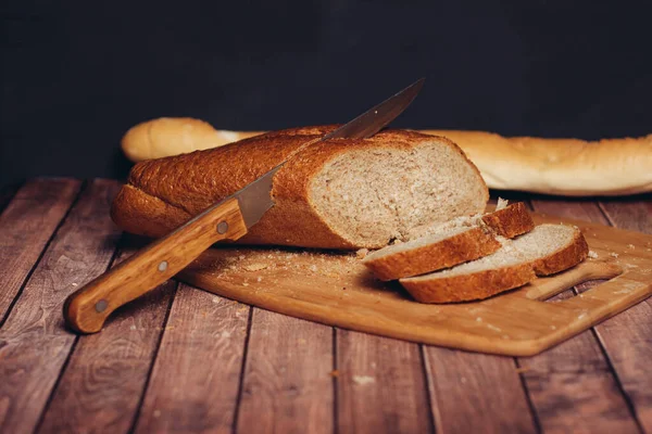 Szeletelt friss kenyér egy fa vágódeszkán konyha — Stock Fotó