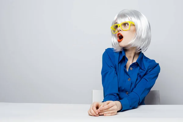 Ελκυστική γυναίκα σε λευκό περούκα κίτρινα γυαλιά κόκκινα χείλη μπλε πουκάμισο — Φωτογραφία Αρχείου