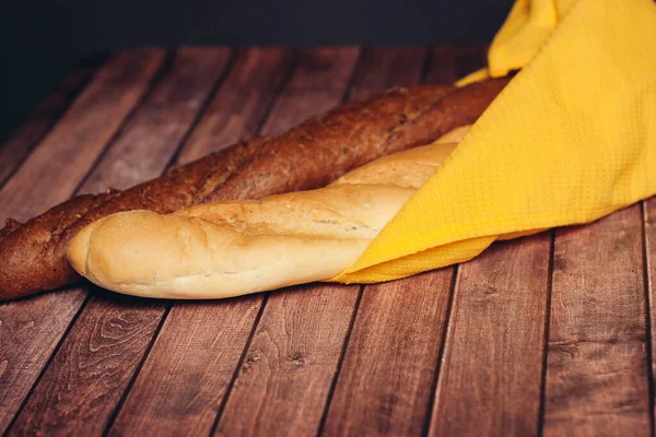 Pão fatiado guardanapo amarelo mesa de madeira assados bens — Fotografia de Stock