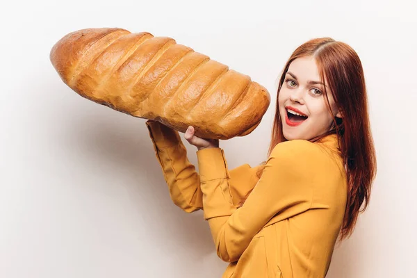 Donna emotiva con un enorme pane su uno sfondo leggero prodotto farina divertente — Foto Stock