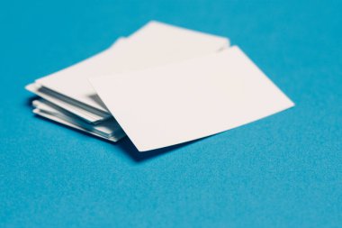 Ofisteki beyaz kartvizitler mavi cam üst görünümde.