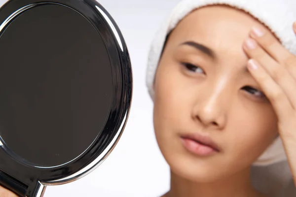 Ασιάτισσα γυναίκα κοιτάζοντας τον καθρέφτη και αγγίζοντας με το πρόσωπό μου καθαρό δέρμα της υγείας κοσμετολογία — Φωτογραφία Αρχείου