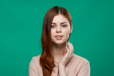 Pembe gömlekli güzel kadın yeşil arka planda el ele tutuşuyor.