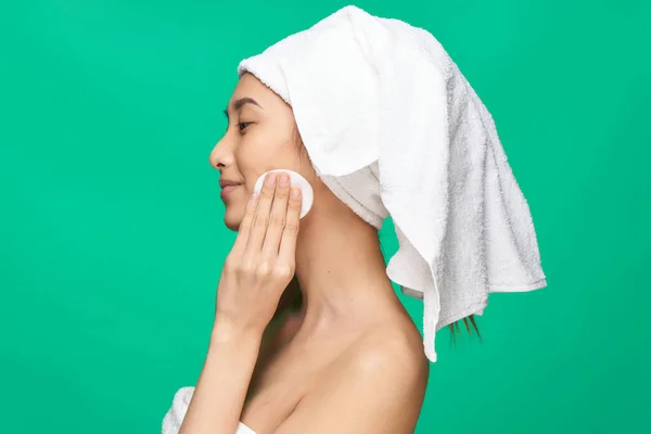 Hübsche Frau nackte Schultern saubere Haut Handtuch auf dem Kopf grünen Hintergrund — Stockfoto