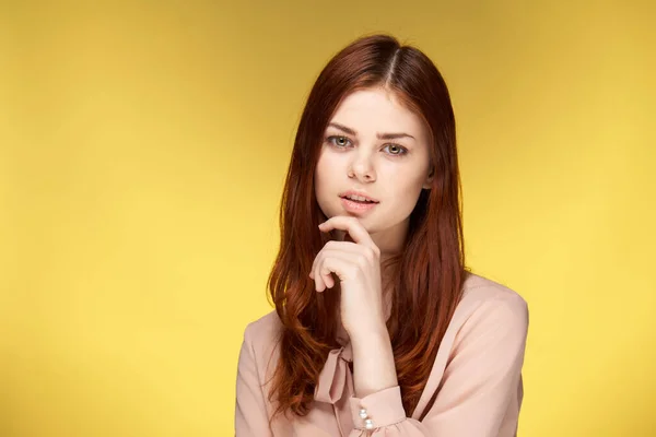 Mooie vrouw houden hand in de buurt gezicht charme luxe gele achtergrond — Stockfoto