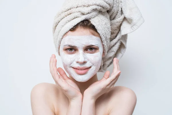 Kvinna med grädde på ansiktet handduk på huvudet hudvård närbild — Stockfoto