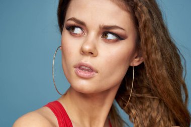 Güzel bir kadın parlak makyaj dalgalı saçlar yakın plan mavi arka plan