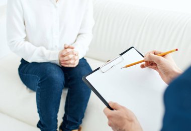 Psikolog resepsiyonundaki bir kadın beyaz bir kanepedir.