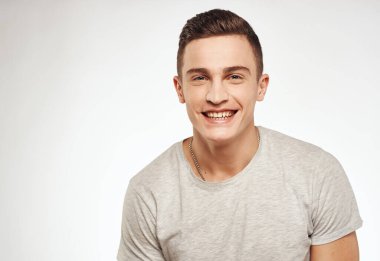 Neşeli, yakışıklı adam gri tişörtlü, kırpık manzaralı.