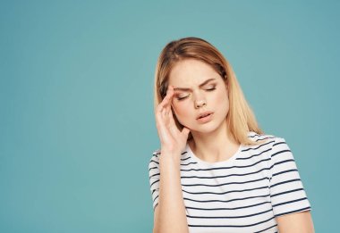 Üzgün kadın ellerini mavi arka plan yakın plan fotokopisi ile yüzüne dokunduruyor.