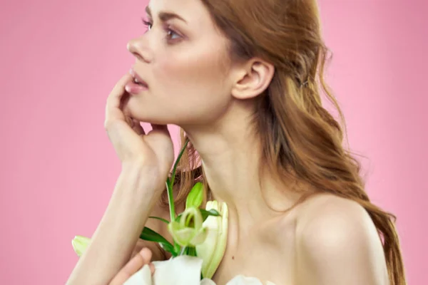 Bílé květy v ženských rukou na růžovém pozadí portrét oříznutý pohled na model make-up — Stock fotografie