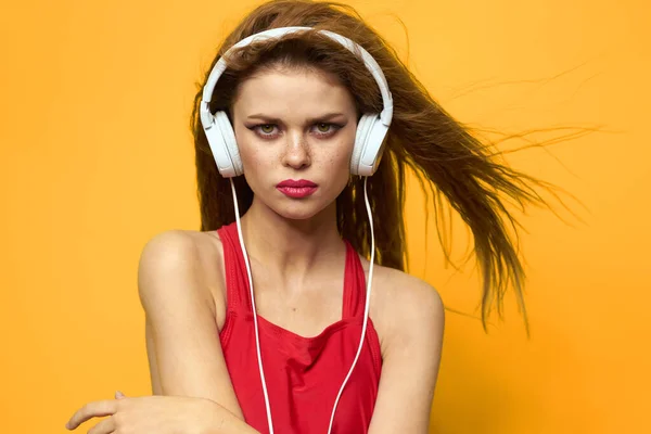 Woman in headphones listening to music red t shirt emotions fashion yellow background lifestyle — Stock Photo, Image