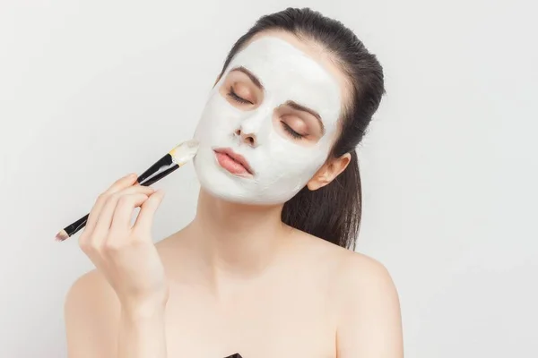 Jolie femme avec masque crème visage soin de la peau épaules nues — Photo