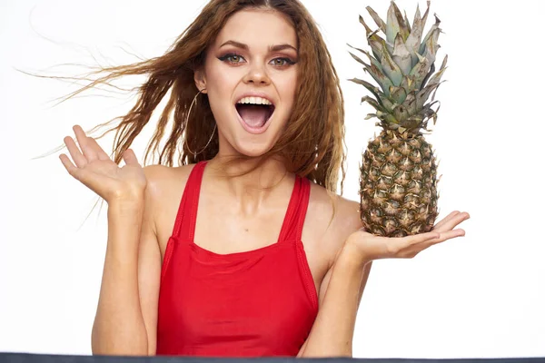 Frau mit Ananas in den Händen welliges Haar rotes T-Shirt Früchte Sommerurlaub Licht Hintergrund — Stockfoto