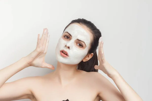 Brunette met crème masker op het gezicht naakte schouders — Stockfoto