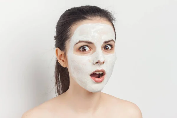 Atractiva morena aplicando máscara en la cara con cepillo cuidado de la piel —  Fotos de Stock