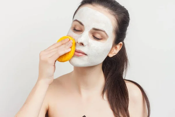 Allegro bruna pulisce la maschera con una spugna scrub skincare — Foto Stock