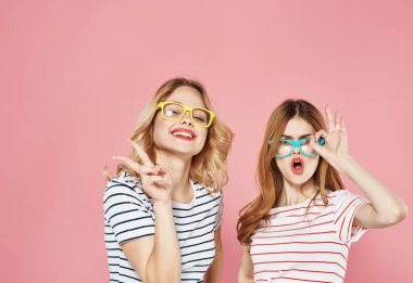 Çizgili tişörtlü ve gözlüklü iki kız arkadaş. Moda zevkli bir yaşam tarzı.