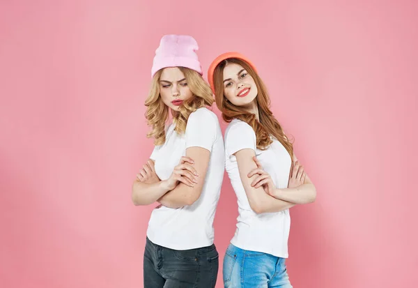 Két csinos nő rózsaszín kalapot visel divatos ruha stúdió kivágott kilátás modell — Stock Fotó